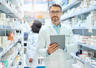 Male pharmacist holding a tablet in a pharmacy